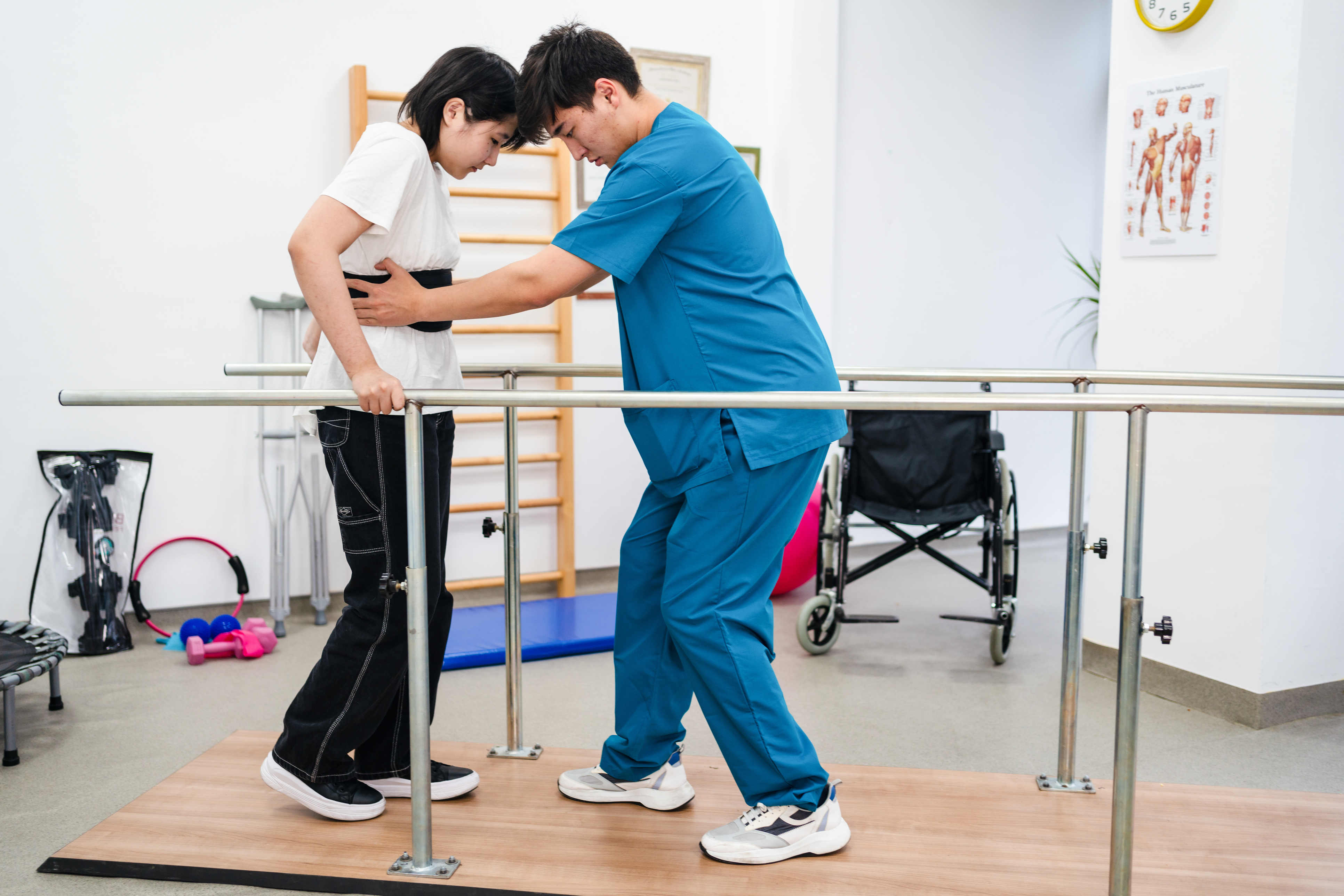 Young patient doing physiotherapy at a clinic with help of a therapist